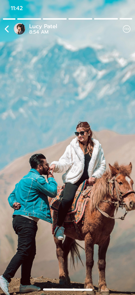 Save Status - Video Saver - 雪山の背景に、馬に乗った女性と彼女の手をキスする男性。 肩に手を置いている。