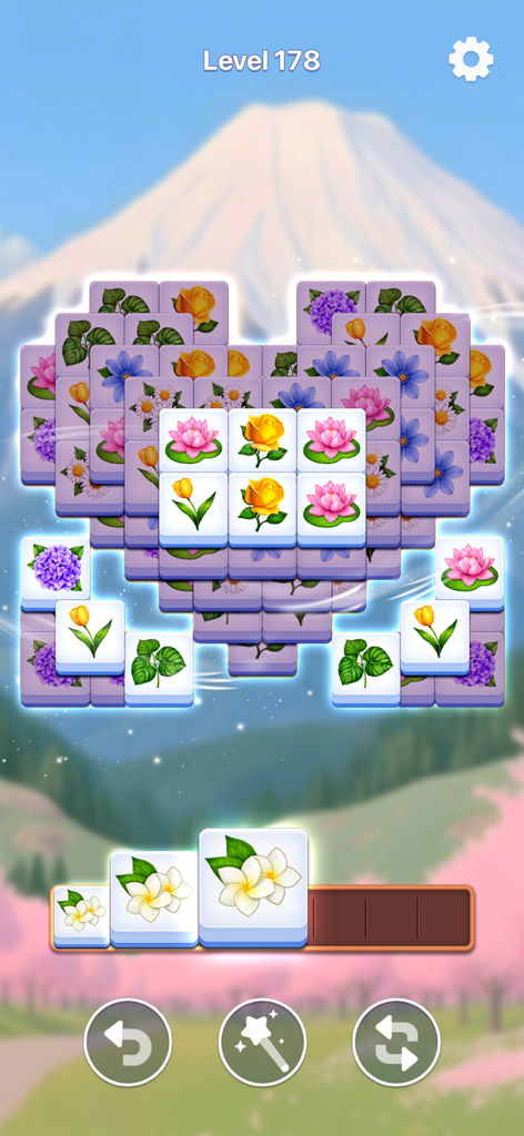 Heart shaped floral tile matching puzzle in a zen game setting with a mountain background