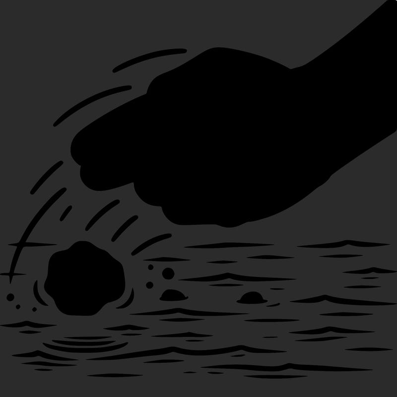 hand throwing rock into water