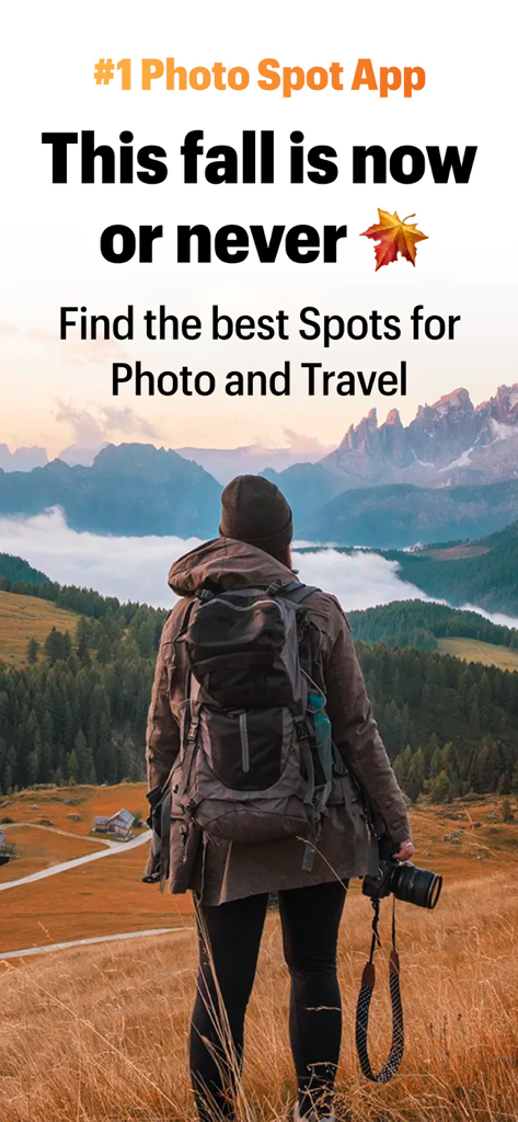 A photographer with a camera overlooking a scenic mountain landscape during autumn