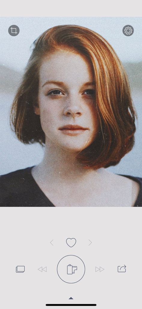 User interface of the RNI Flashback app featuring a portrait with a nostalgic analog film effect and a central film roll button