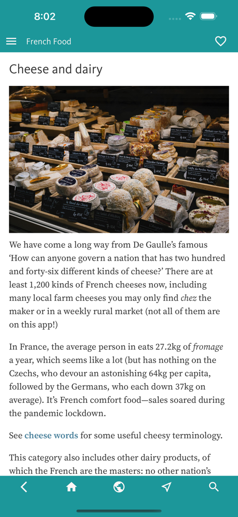 French Food Decoder - Una captura de pantalla de la aplicación French Food Decoder que muestra un artículo sobre quesos y productos lácteos franceses con una foto de una exhibición en una tienda de quesos.