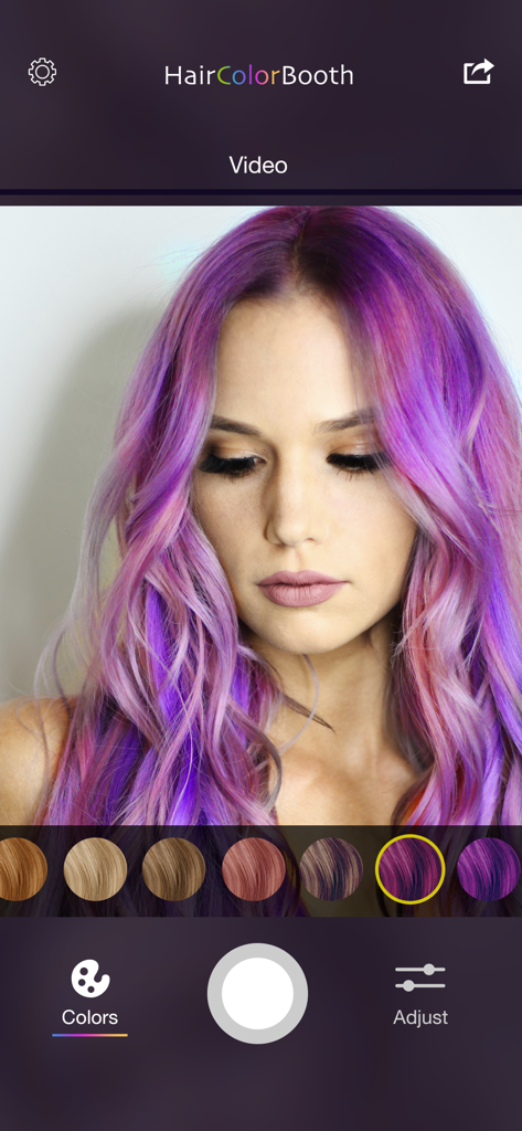 Hair Color Booth™ - User interface of Hair Color Booth app featuring a model with purple hair and color selection swatches