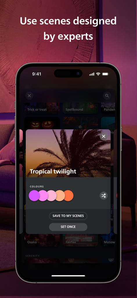 Philips Hue - 보라, 분홍, 주황의 일몰 색상 팔레트가 특징인 '열대 휴양지의 황혼' 조명 장면이 선택된 Philips Hue 앱이 표시된 스마트폰