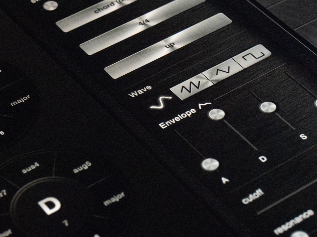 polychord - Interface du synthétiseur de l'application Polychord montrant la sélection de la forme d'onde et les contrôles d'enveloppe sur un fond métallique sombre brossé.