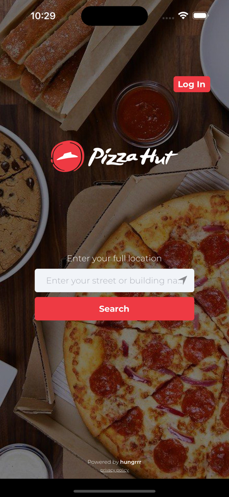 Pantalla de inicio de la aplicación móvil Pizza Hut Curacao con búsqueda de ubicación y fondo de pizza