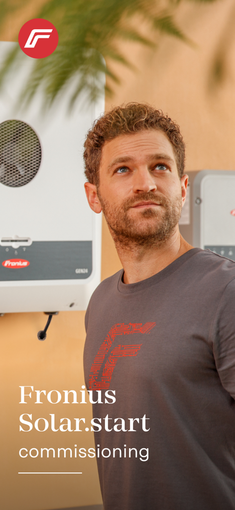 Solar installer standing next to a Fronius inverter for system commissioning