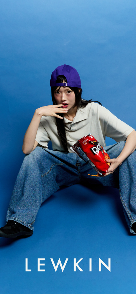 LEWKIN - Modelo posando con ropa de calle coreana, pantalones holgados y gorra morada para LEWKIN.