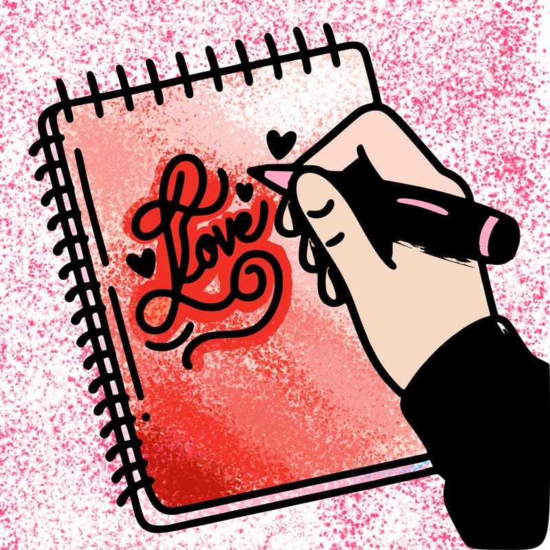 a hand writing “love” in calligraphy on a notebook