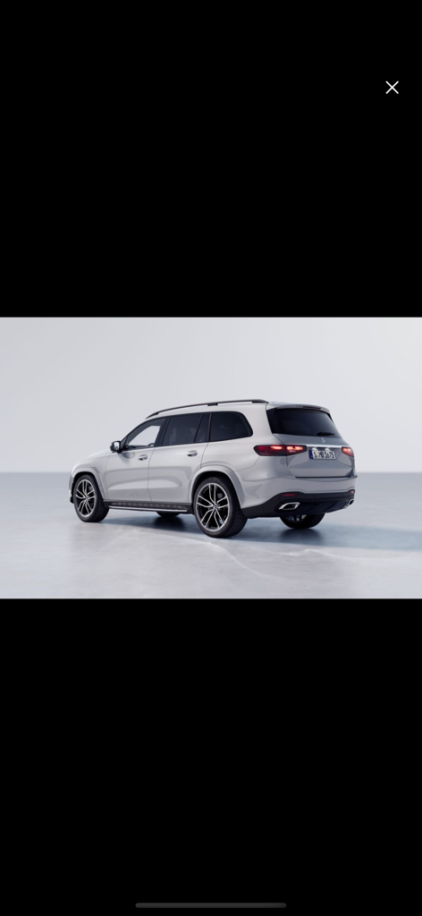 Rear view of a silver Mercedes Benz SUV in a studio setting