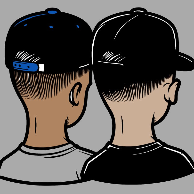 low taper fade with a backwards hat and a blue shirt