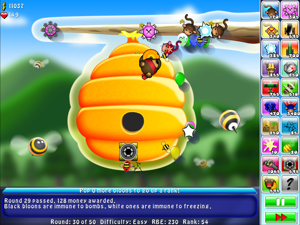 Gameplay screenshot of Bloons TD 4 HD featuring monkeys defending a beehive map against colorful balloons