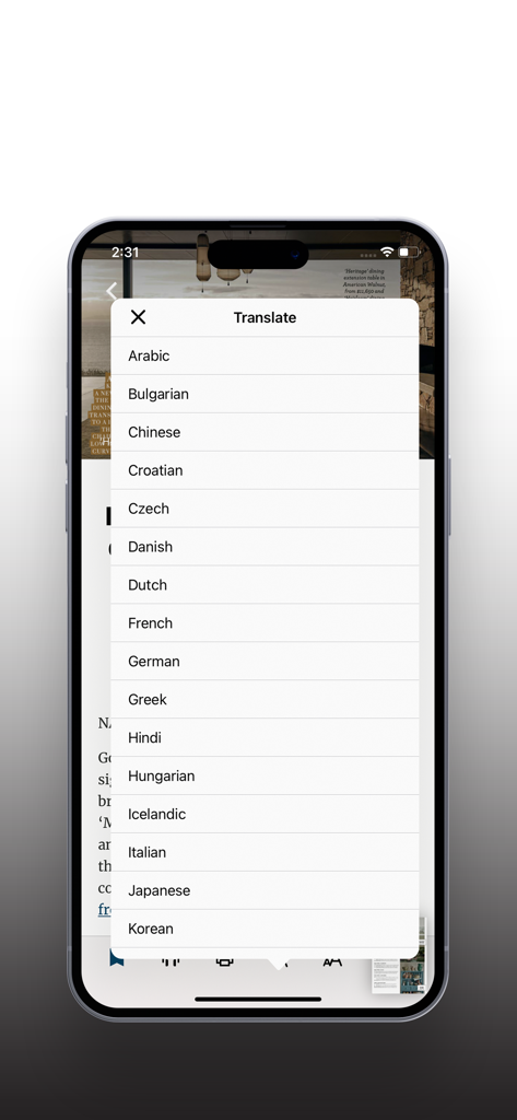 A smartphone displaying the Home Beautiful app with a language translation menu open over an interior design article.