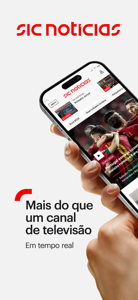 SIC Notícias - Mão segurando um smartphone mostrando o aplicativo SIC Noticias com cobertura de notícias e desporto em tempo real em português.