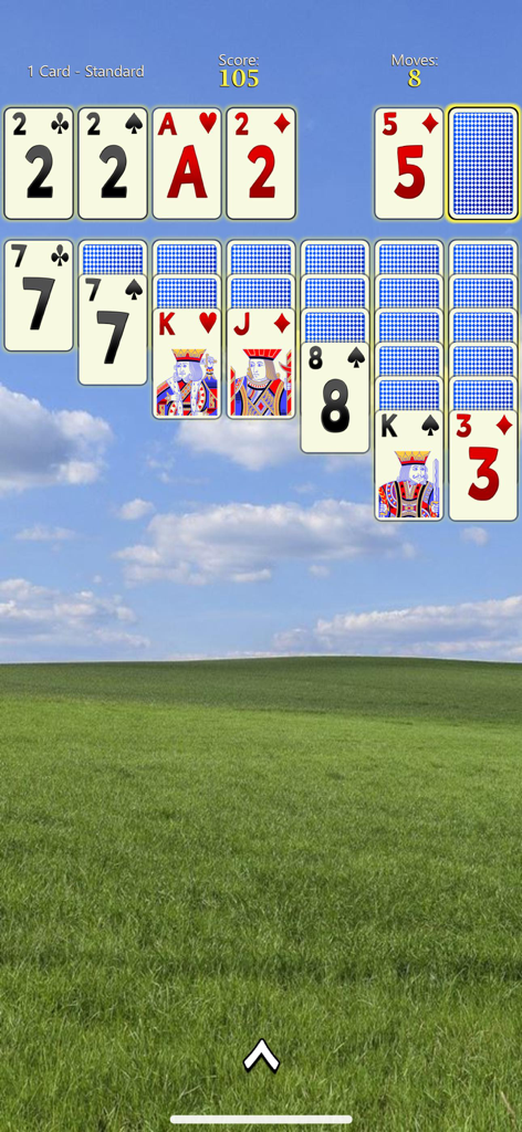 Solitaire Mobile - Solitaire Mobile gameplay screen showing large cards with big numbers over a scenic green field and blue sky background