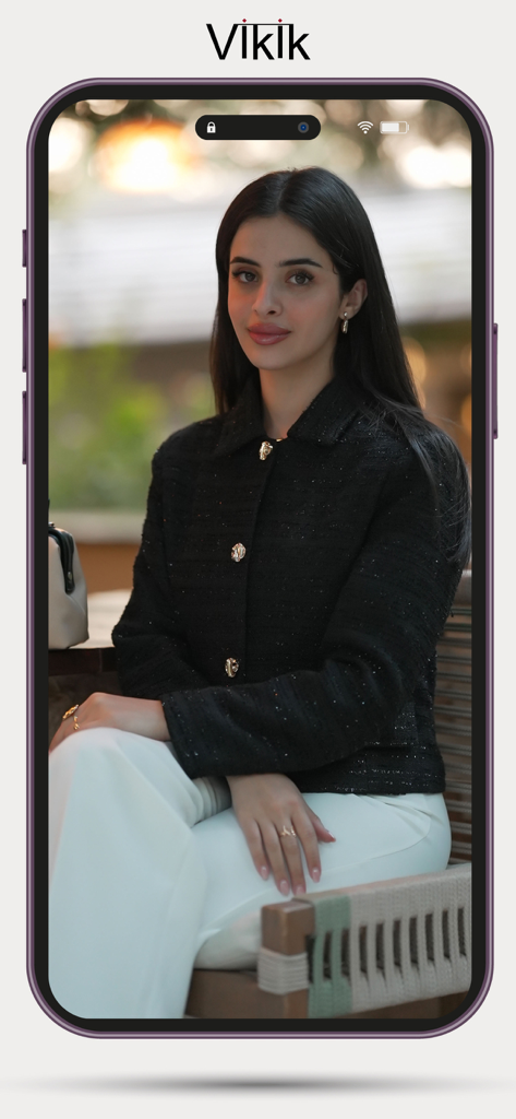 Vikik - Uma jovem usando uma jaqueta preta da moda e calças brancas apresentada na tela do aplicativo de compras Vikik.