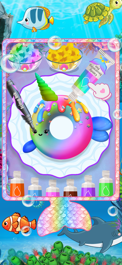 Ein bunter Minispielbildschirm, auf dem Spieler einen regenbogenfarbenen fischförmigen Donut mit Zuckergussstiften im Unterwassermotiv dekorieren.