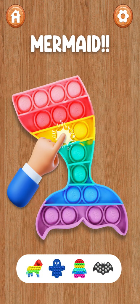 A rainbow colored mermaid tail shaped pop it fidget toy being pressed by a hand on a wooden background.