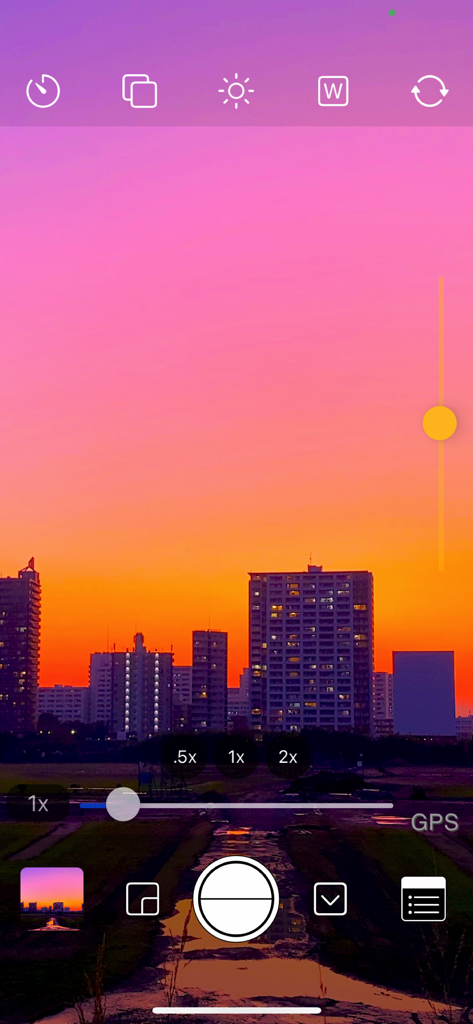 OneCam 2 manual camera interface with exposure controls and a sunset city skyline view