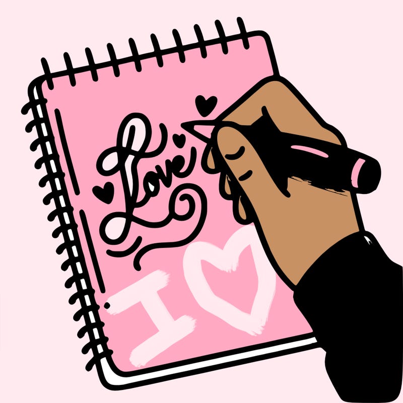 a hand writing “love” in calligraphy on a notebook