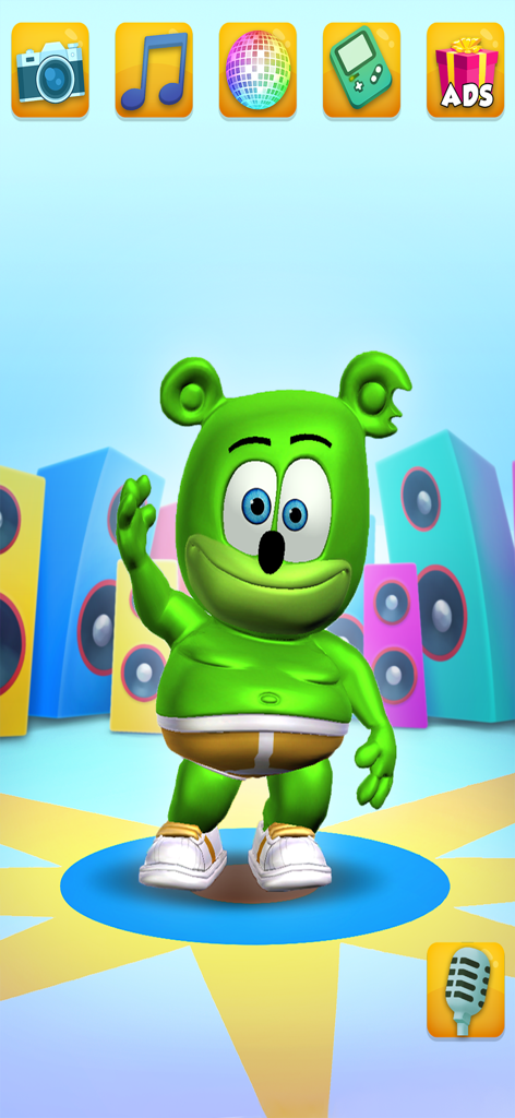 My Talking Gummy Bear - Personaje de osito gominola verde saludando en un escenario con altavoces e iconos de juegos