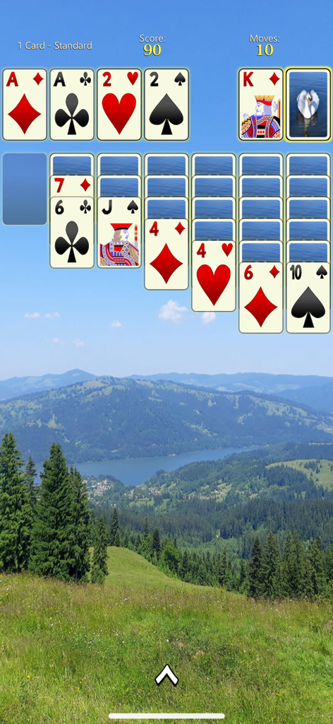 Solitaire Mobile - Solitaire game screen with large cards over a scenic mountain and lake background