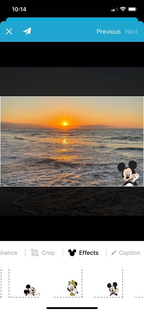 A sunset photo with a Mickey Mouse digital sticker being edited in the PhotoShare Frame app.