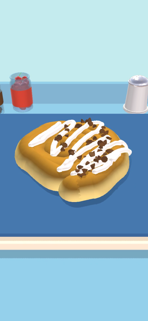 Bake it - Une pâtisserie dorée décorée de glaçage blanc et de copeaux de chocolat dans le jeu Bake it.