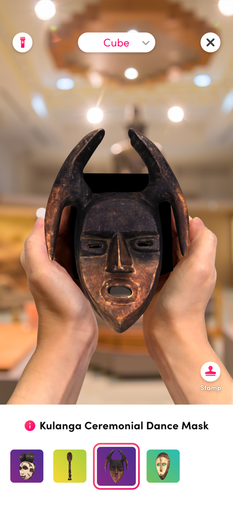 Merge Object Viewer - Une personne regardant un masque de danse cérémoniel Kulanga 3D en réalité augmentée à l'aide de l'application Merge Object Viewer.