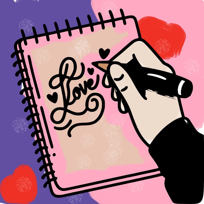 a hand writing “love” in calligraphy on a notebook