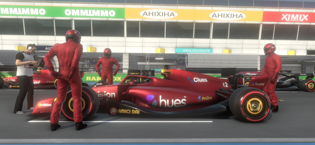 Monoposto - クルーメンバーがいるピットストップの赤いフォーミュラレーシングカー