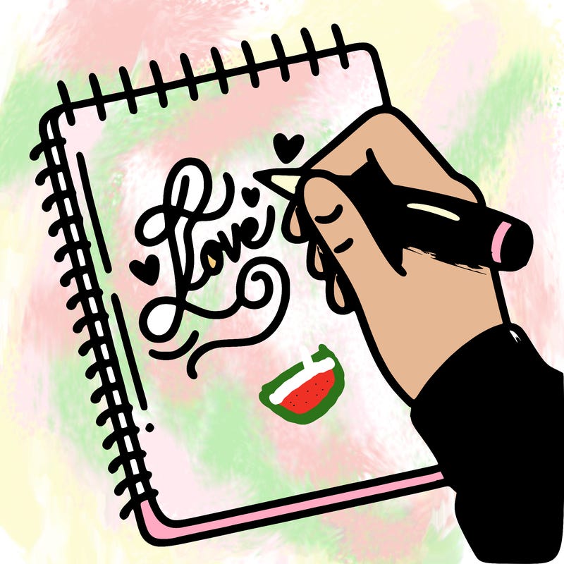 a hand writing “love” in calligraphy on a notebook