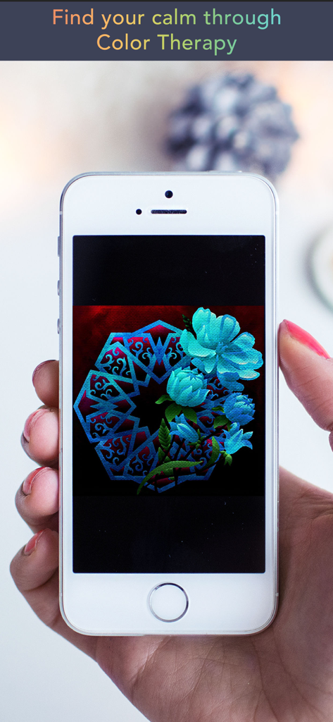 Eine Hand, die ein iPhone hält, auf dem ein fertiges blaues Blumen- und Mandala-Kunstwerk in der Color Therapy-App zu sehen ist