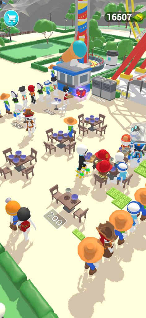 Dream Park : Wonderland Tycoon - Una vista cenital de una escena de gestión de parques de atracciones con visitantes comiendo en mesas y haciendo cola para las atracciones