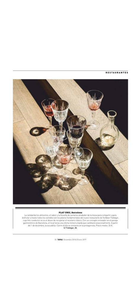 An elegant editorial page from TAPAS Magazine featuring crystal glassware and a review of a Barcelona restaurant