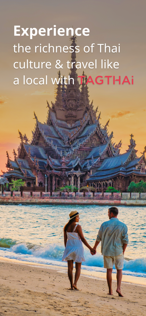 A couple walking on a beach in front of a traditional Thai wooden temple