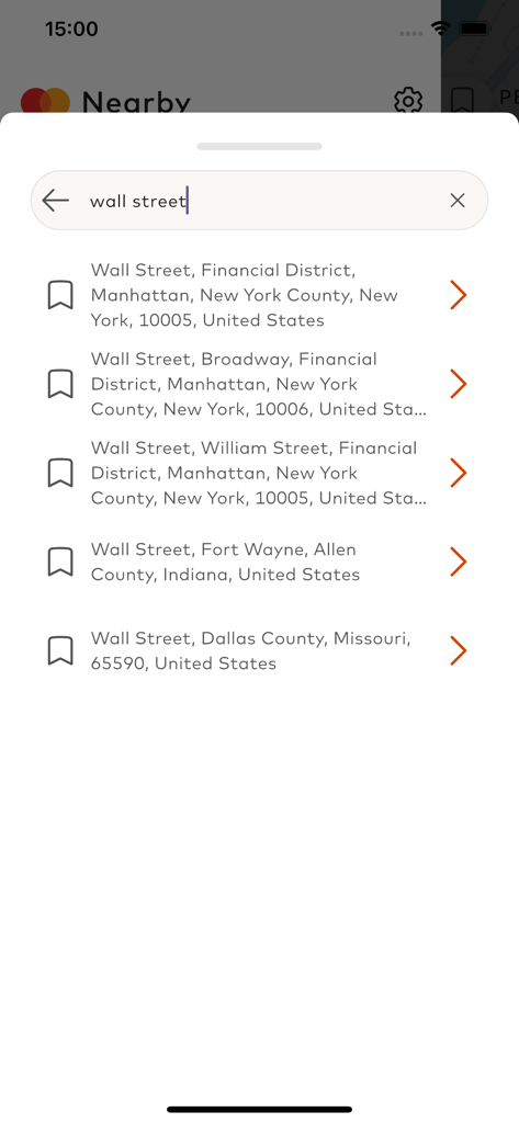 Mobile app interface of Mastercard Nearby showing a search for Wall Street with multiple address suggestions