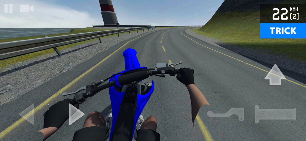 First-person view of a blue motocross bike riding on a coastal road with a lighthouse in the background