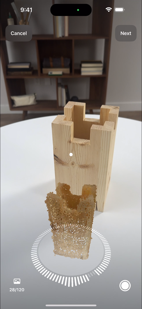 A user capturing a 3D model of a wooden object using the Reality Composer app photogrammetry feature on an iPhone.