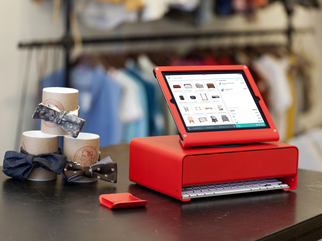 iPad running the Hike POS Register app on a modern red stand in a boutique setting