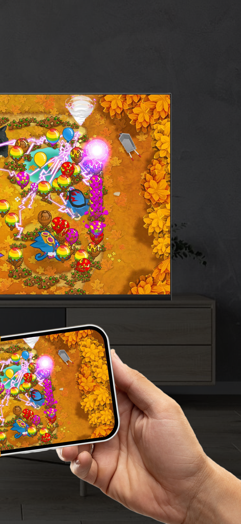 An iPhone screen mirroring a colorful mobile game onto a large flat-screen TV in a living room