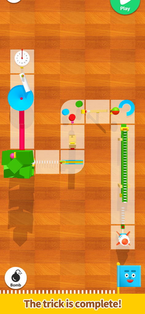 Pocket Marble Runs - 木製の床の上に配置された、カラフルな部品と青い旗がある完成したマーブルランマシンのレイアウト