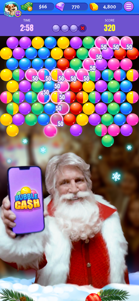 Santa Claus sosteniendo un smartphone con el logo de Bubble Cash sobre una pantalla de juego de shooter de burbujas