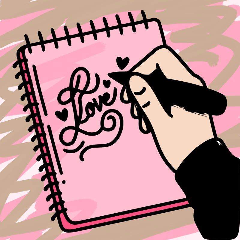 a hand writing “love” in calligraphy on a notebook