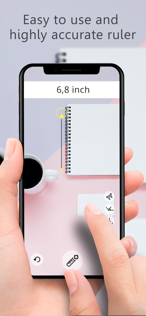 Ruler AR - Tape Measure Camera - A hand holding a smartphone using the Ruler AR app to measure a notebook on a desk