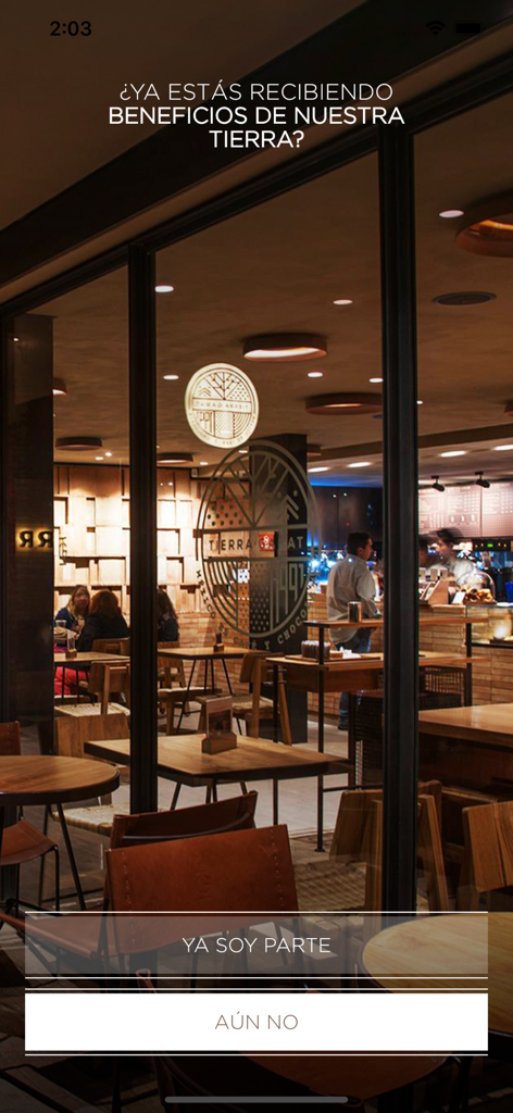 Tierra Garat - Pantalla de incorporación de la app Tierra Garat con una vista del acogedor interior de una cafetería artesanal