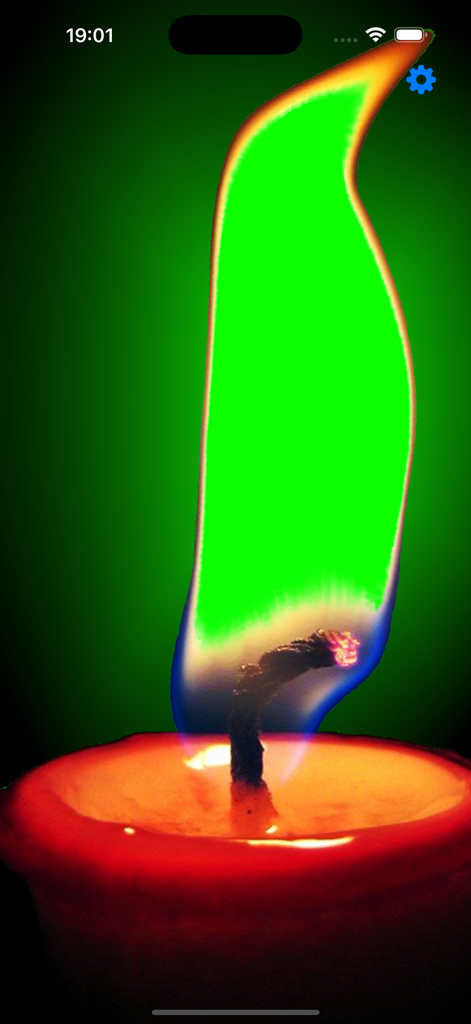 Um close-up de uma vela vermelha com uma grande chama verde brilhante em uma tela de celular.