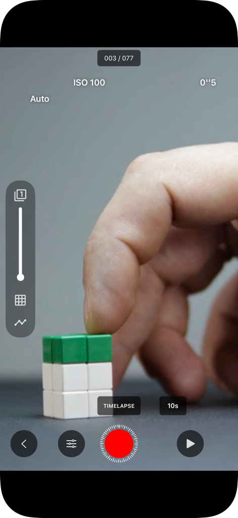 A hand positioning toy blocks while using the manual camera controls in the Stop Motion Studio app