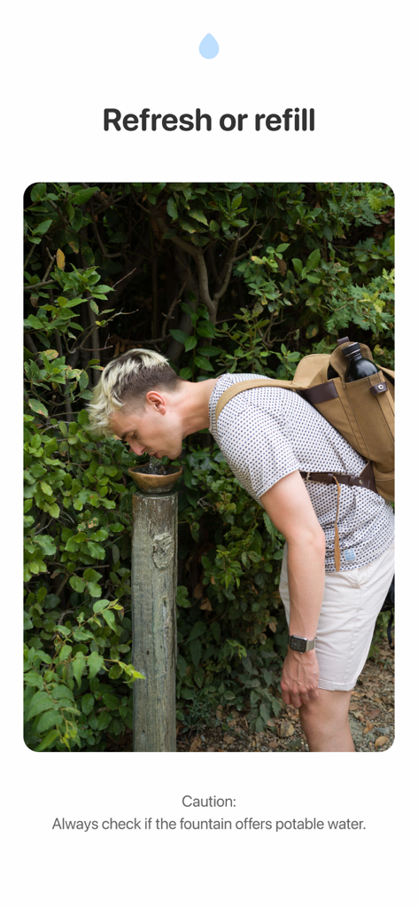 Fountain Finder - A man wearing a backpack drinks from an outdoor public water fountain in a park