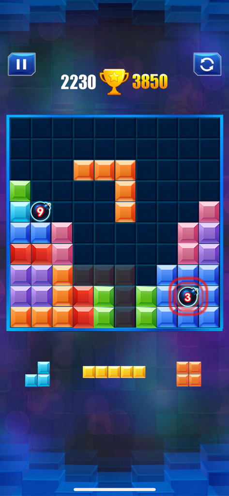 Vista de jogo do Block Puzzle apresentando uma grelha 10x10 com blocos coloridos e obstáculos de bombas.